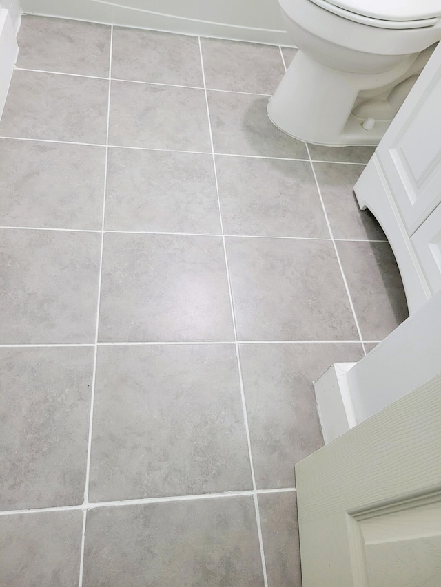 bathroom with toilet and tile patterned flooring