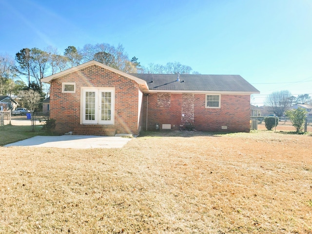 back of property featuring a patio area and a lawn