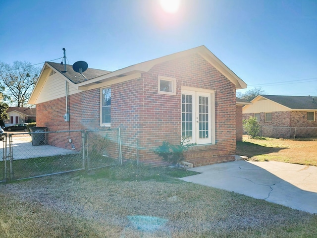 view of home's exterior featuring a patio area, french doors, and a lawn