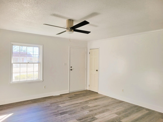 empty room featuring a textured ceiling, ceiling fan, and hardwood / wood-style flooring