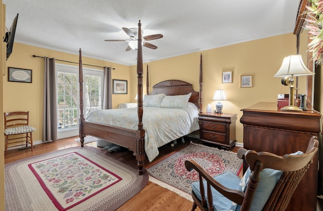 bedroom with light hardwood / wood-style flooring, a textured ceiling, ceiling fan, access to exterior, and ornamental molding