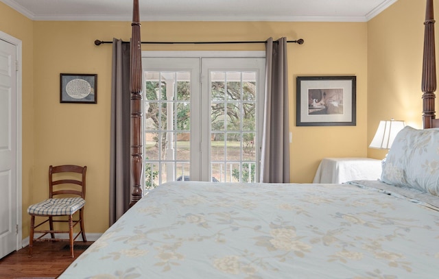 bedroom featuring dark hardwood / wood-style flooring, ornamental molding, and access to exterior