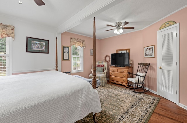 bedroom with multiple windows, ornamental molding, hardwood / wood-style flooring, and a textured ceiling