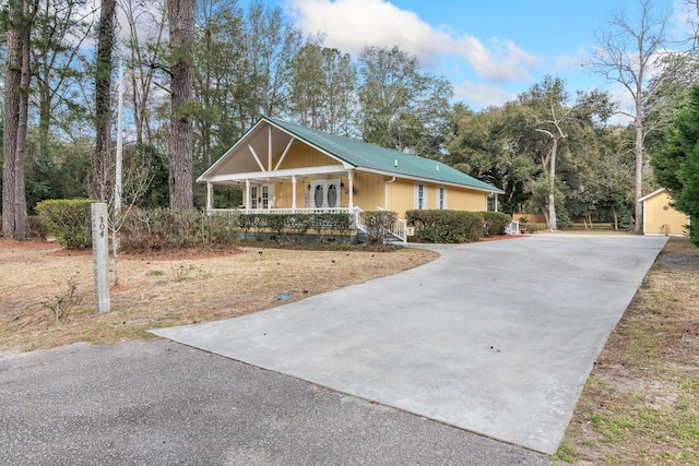 view of front of home with a storage shed and a porch