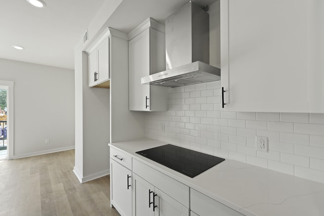 564 Scholar Way, Summerville, SC 29486 - kitchen with wall chimney exhaust hood, black electric cooktop, light wood-style floors, white cabinets, and decorative backsplash