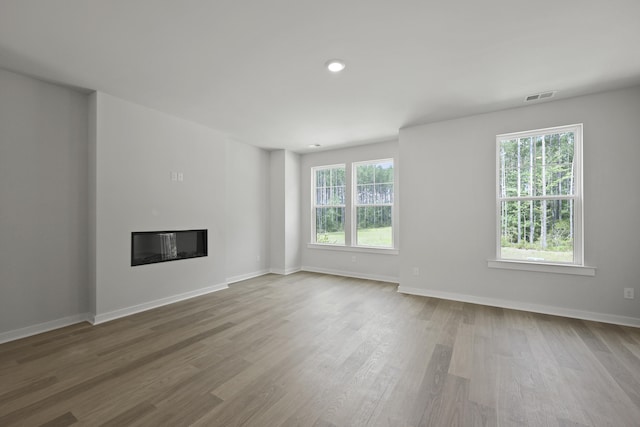 564 Scholar Way, Summerville, SC 29486 - unfurnished living room featuring a glass covered fireplace, wood finished floors, and recessed lighting