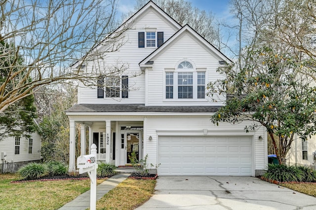 traditional-style home featuring concrete driveway, an attached garage, and a porch