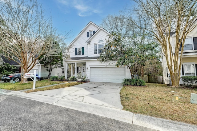 traditional-style house with driveway, a front yard, an attached garage, and fence