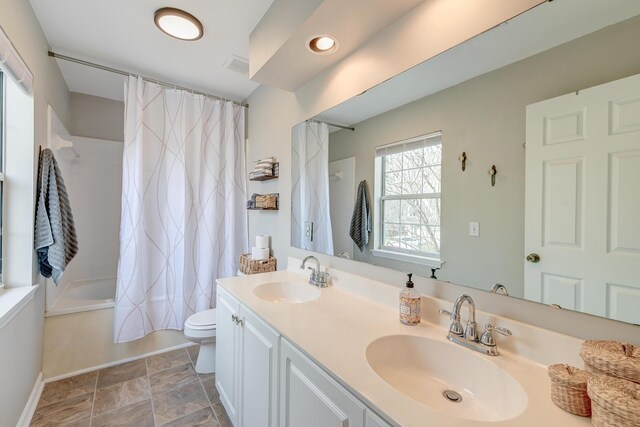 full bathroom with double vanity, shower / tub combo, toilet, and a sink