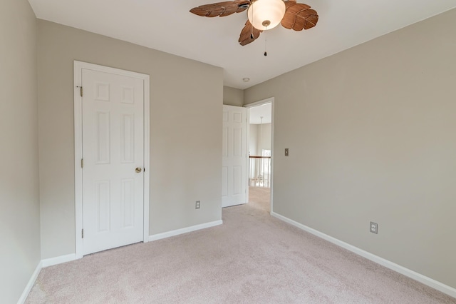 unfurnished bedroom with a ceiling fan, baseboards, and light carpet