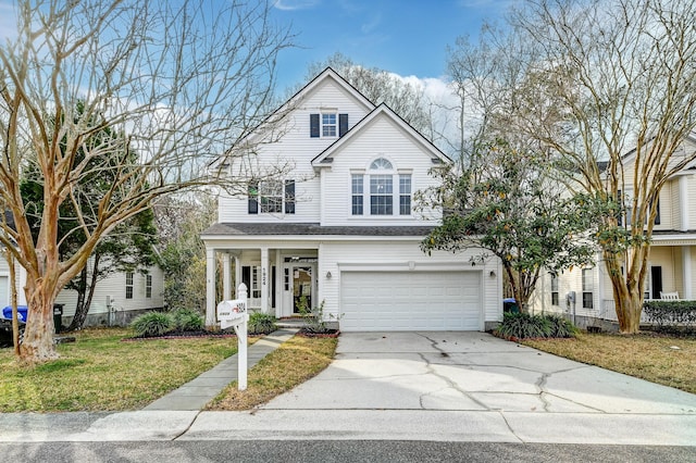 traditional home featuring a front yard, an attached garage, covered porch, and driveway