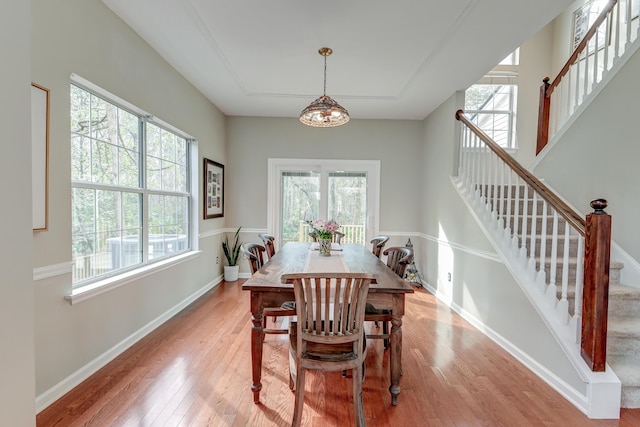 dining area with stairway, light wood-style floors, and baseboards