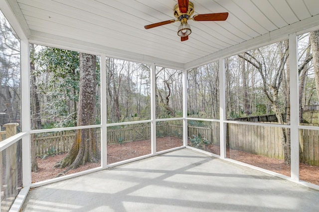 unfurnished sunroom with a ceiling fan and a wealth of natural light