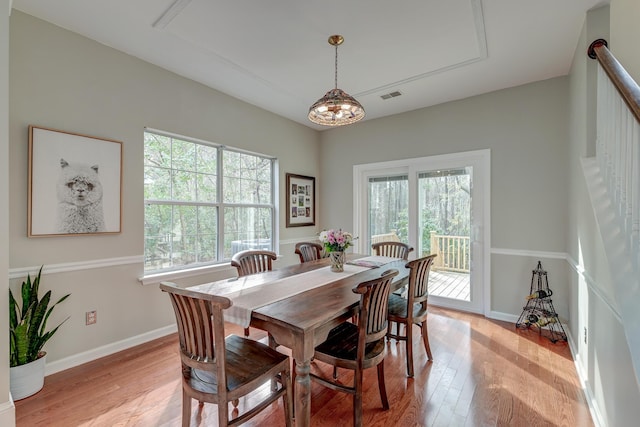 dining room featuring stairway, light wood-style floors, visible vents, and baseboards