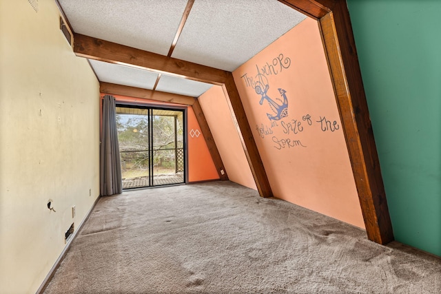 carpeted empty room featuring a textured ceiling and vaulted ceiling