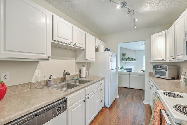 kitchen featuring a textured ceiling, dark wood-type flooring, sink, white cabinetry, and white appliances