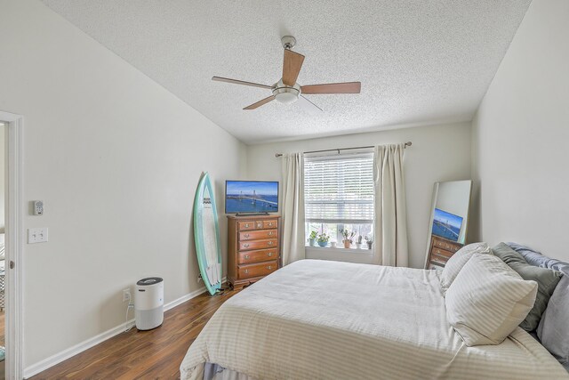 bedroom with a textured ceiling, dark hardwood / wood-style floors, and ceiling fan