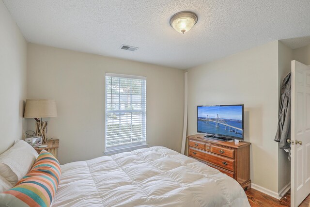 bedroom featuring a textured ceiling and hardwood / wood-style flooring