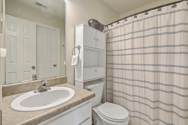 bathroom with a shower with curtain, vanity, and toilet