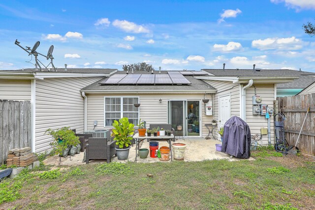 rear view of property with solar panels, a yard, a patio area, and central air condition unit