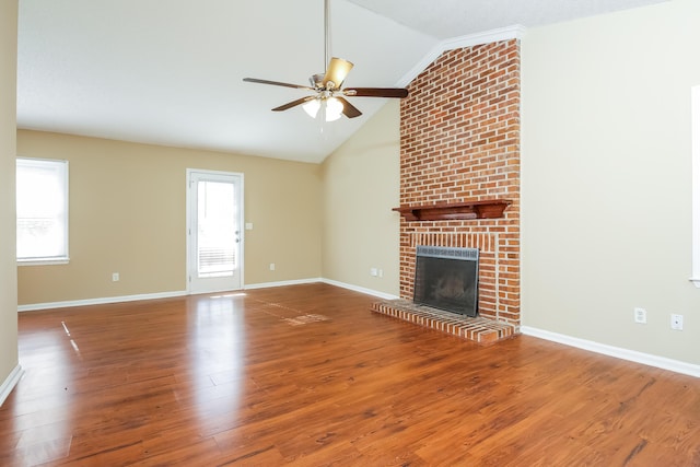 unfurnished living room featuring ceiling fan, wood-type flooring, lofted ceiling, and a brick fireplace