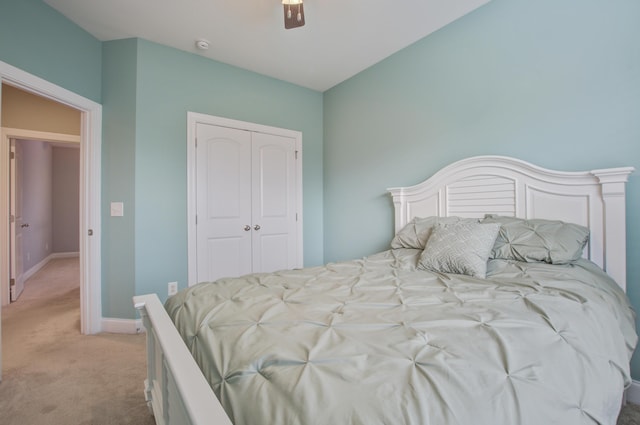 bedroom with a closet, ceiling fan, and light colored carpet