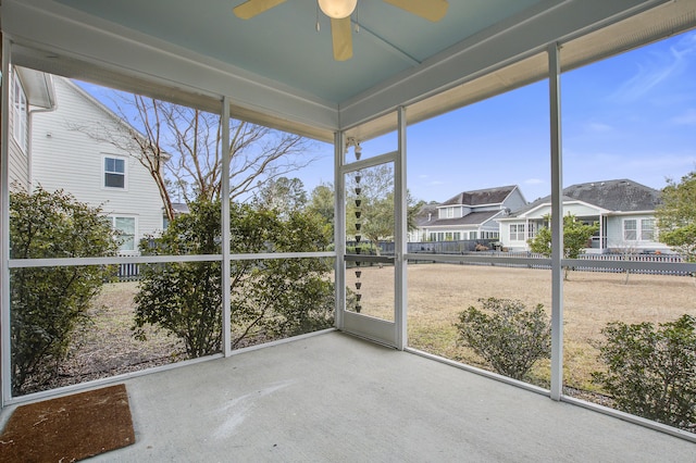 unfurnished sunroom featuring ceiling fan and a wealth of natural light