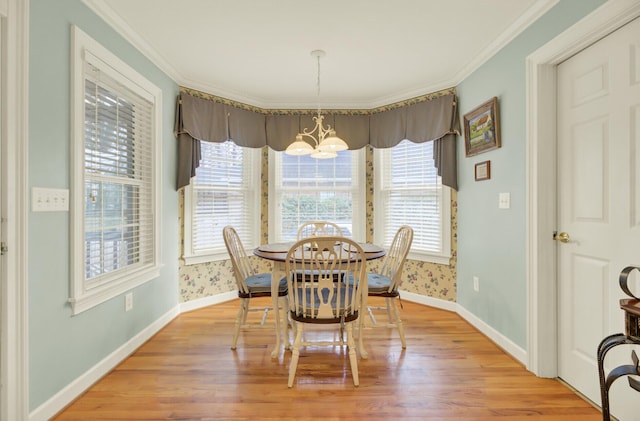 dining area featuring light wood-type flooring, a notable chandelier, and wallpapered walls