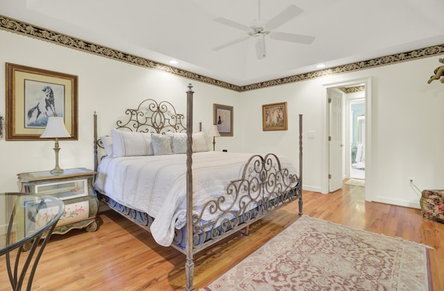 bedroom with ceiling fan, wood finished floors, and baseboards