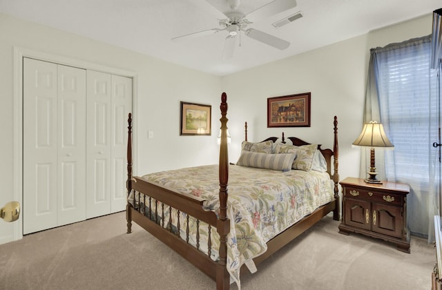 bedroom with a ceiling fan, visible vents, a closet, and light colored carpet