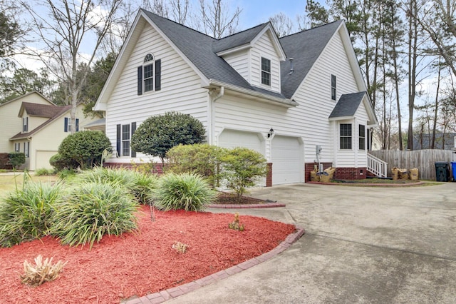 view of front of house featuring a garage, fence, concrete driveway, and roof with shingles