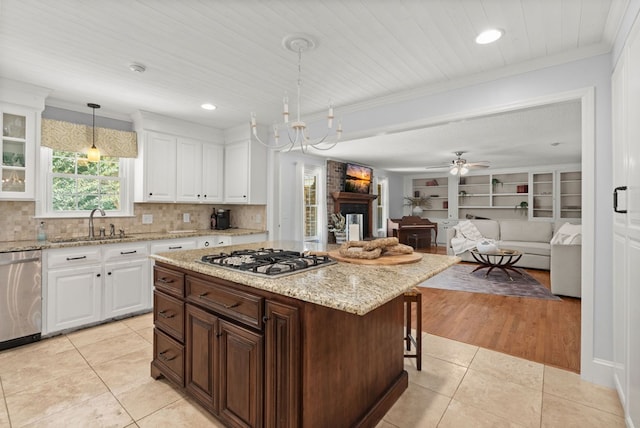 kitchen with stainless steel appliances, hanging light fixtures, light tile patterned floors, and white cabinetry