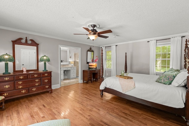 bedroom featuring wood-type flooring, ornamental molding, ensuite bathroom, and ceiling fan