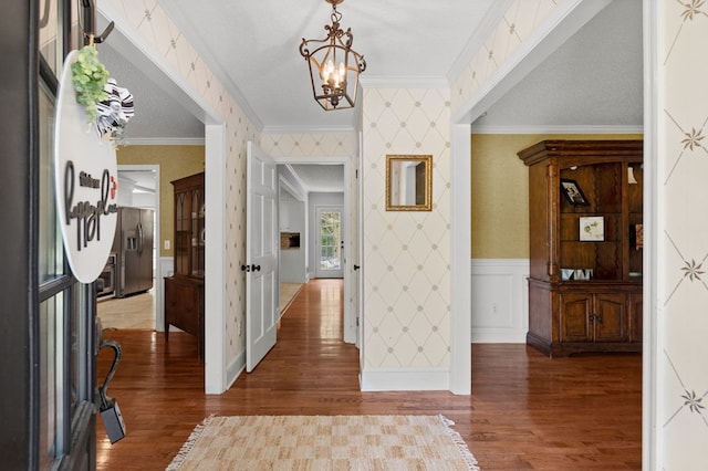 foyer featuring ornamental molding, a textured ceiling, a chandelier, and dark wood-type flooring