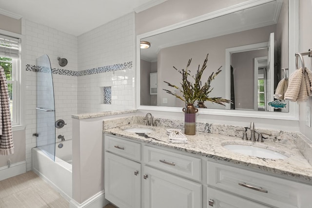 bathroom featuring plenty of natural light, ornamental molding, tiled shower / bath, and vanity