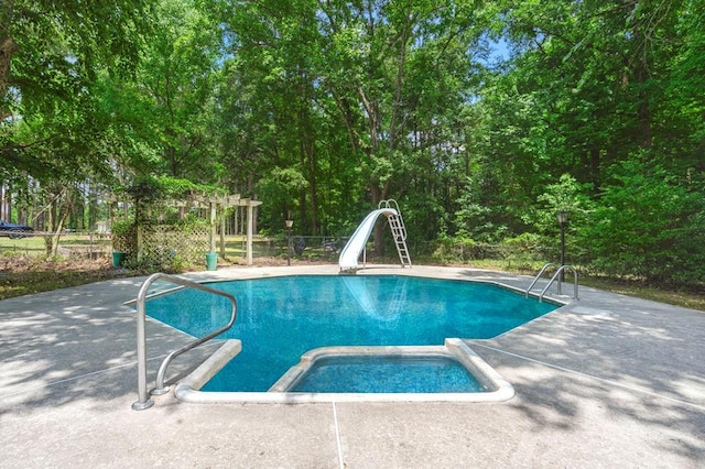 view of pool with a water slide and a patio