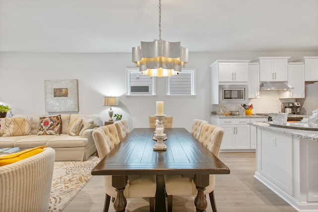 dining area featuring a chandelier and light wood-type flooring