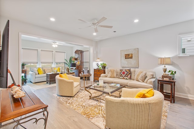 living area with a healthy amount of sunlight, light wood-style floors, and a ceiling fan