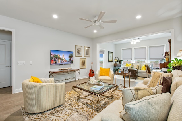 living room with baseboards, ceiling fan, recessed lighting, and light wood-type flooring