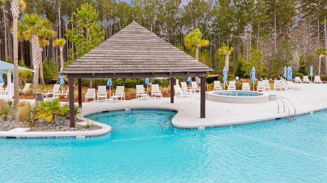 pool with a community hot tub, fence, a gazebo, and a patio area