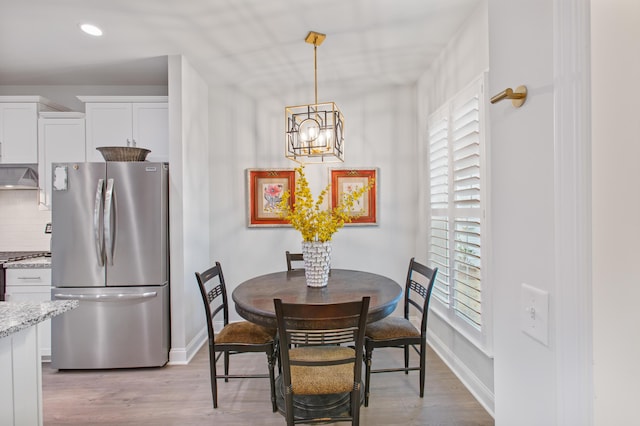 dining area featuring baseboards, light wood-style floors, a chandelier, and recessed lighting