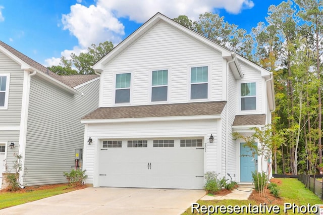 view of front of house featuring a garage, driveway, and a shingled roof