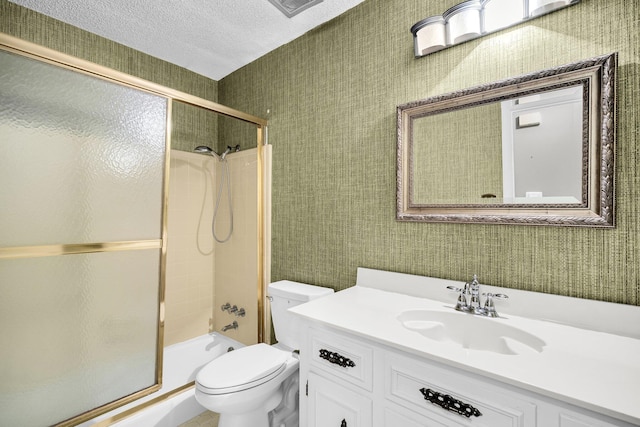 full bathroom with vanity, combined bath / shower with glass door, a textured ceiling, and toilet