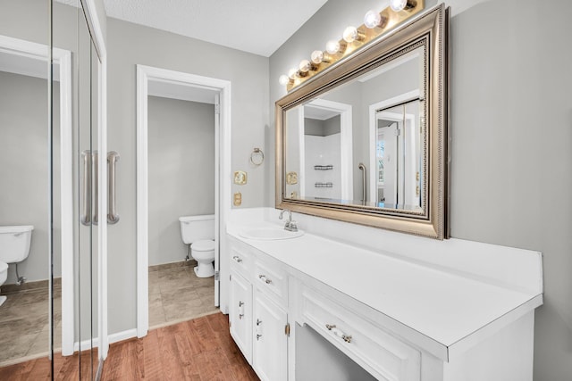 bathroom featuring vanity, hardwood / wood-style floors, and toilet