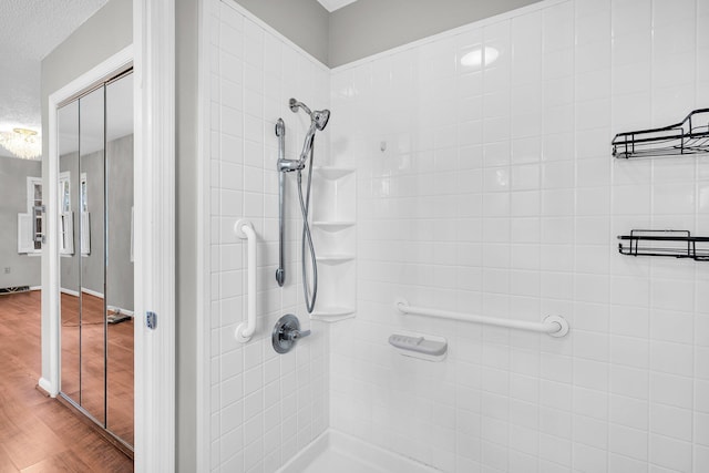 bathroom featuring hardwood / wood-style flooring and tiled shower