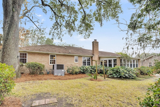 back of property with a yard and central air condition unit