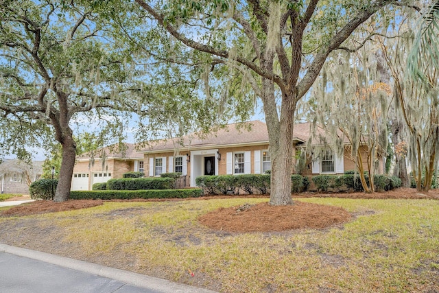 ranch-style home featuring a garage and a front yard