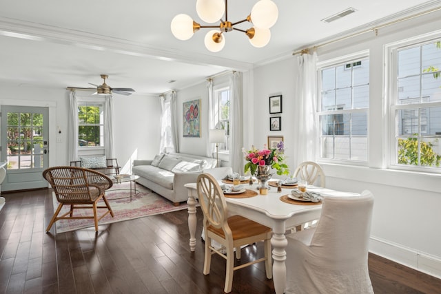 dining space featuring dark wood finished floors, a wealth of natural light, and crown molding