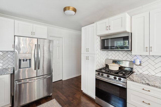 kitchen featuring white cabinets, dark wood finished floors, stainless steel appliances, light stone countertops, and tasteful backsplash