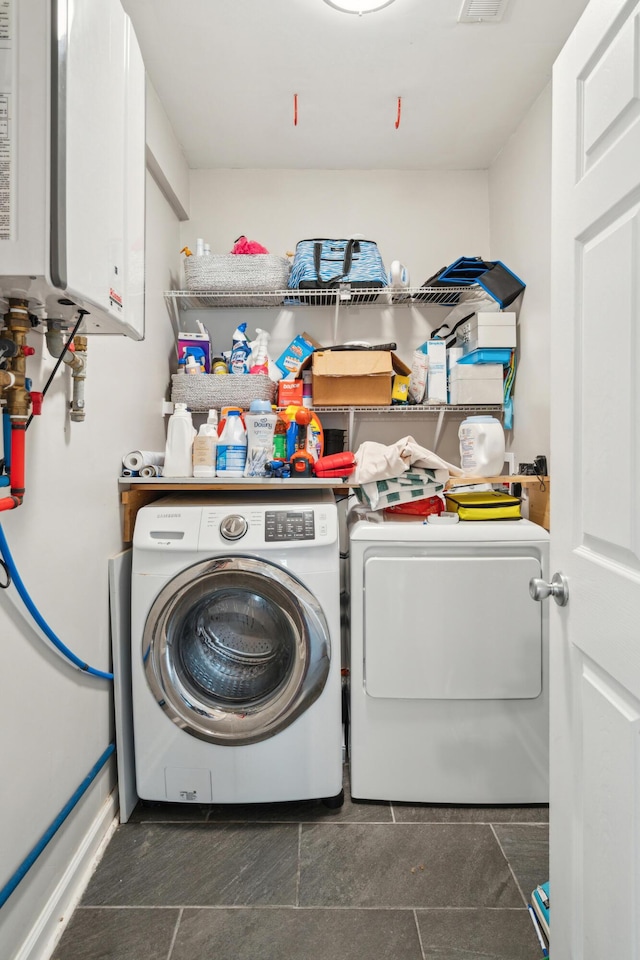 laundry area featuring water heater, washer and dryer, and laundry area
